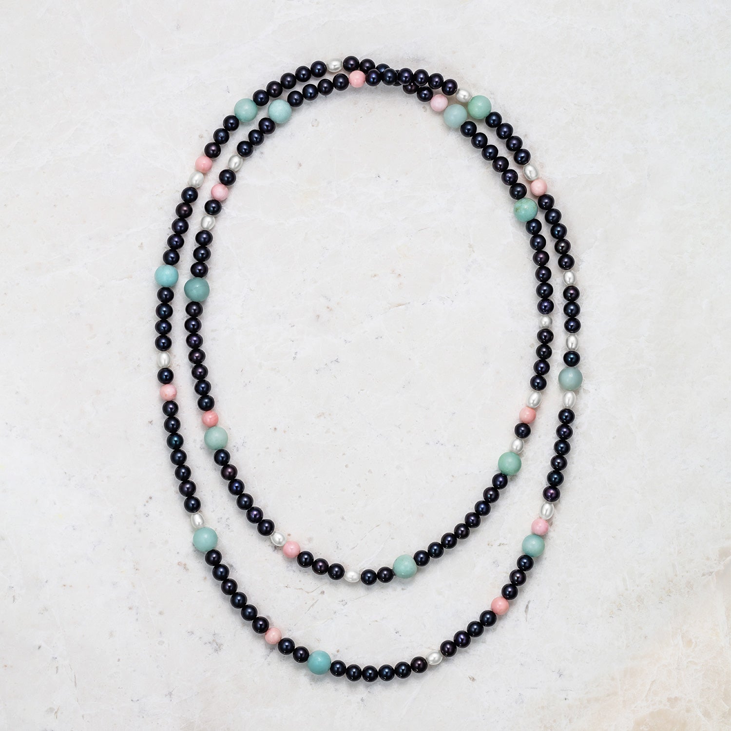 A Long Pearl & Bead Necklace with a set of black and white Akoya pearls, strung with amazonite beads and knotted on dark grey thread. Total necklace length is 50".