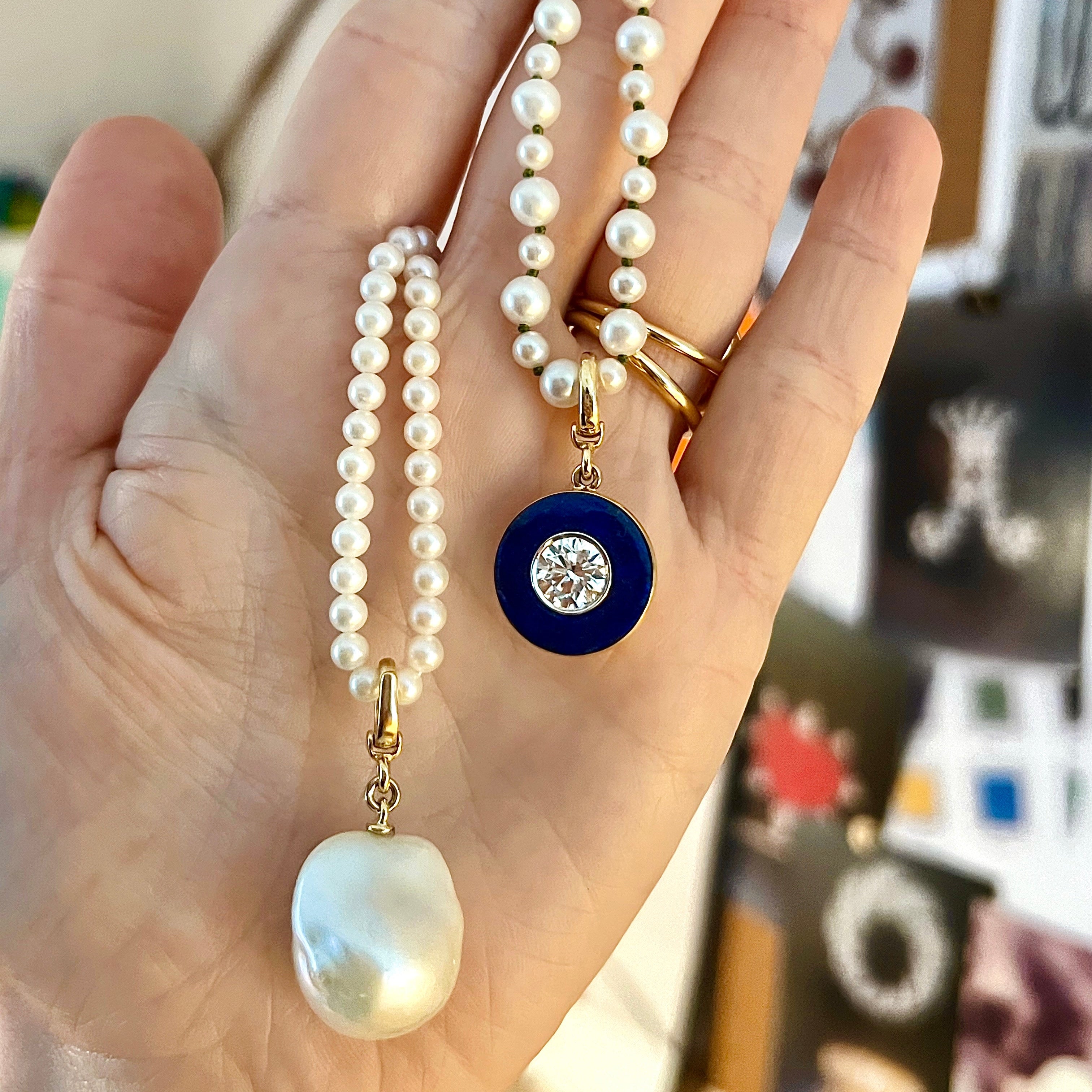 Handcrafted 18K yellow gold Diamond Lapis Pendant featuring a 1.55ct round brilliant lab grown diamond surrounded by a deep blue lapis lazuli inlay with a detachable clasp on white pearl necklace by Isabella Roux.