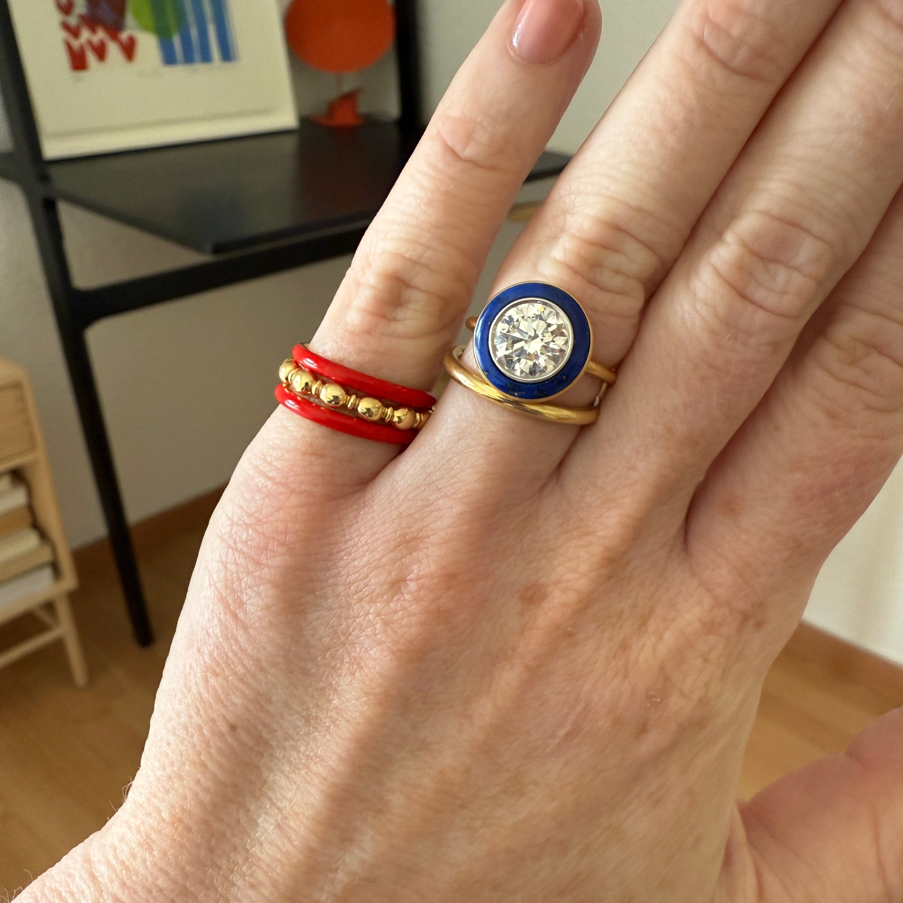 Hand wearing 18K yellow gold Energy Gold Band featuring a unique coloured enamel finish and solid gold profile by Isabella Roux.