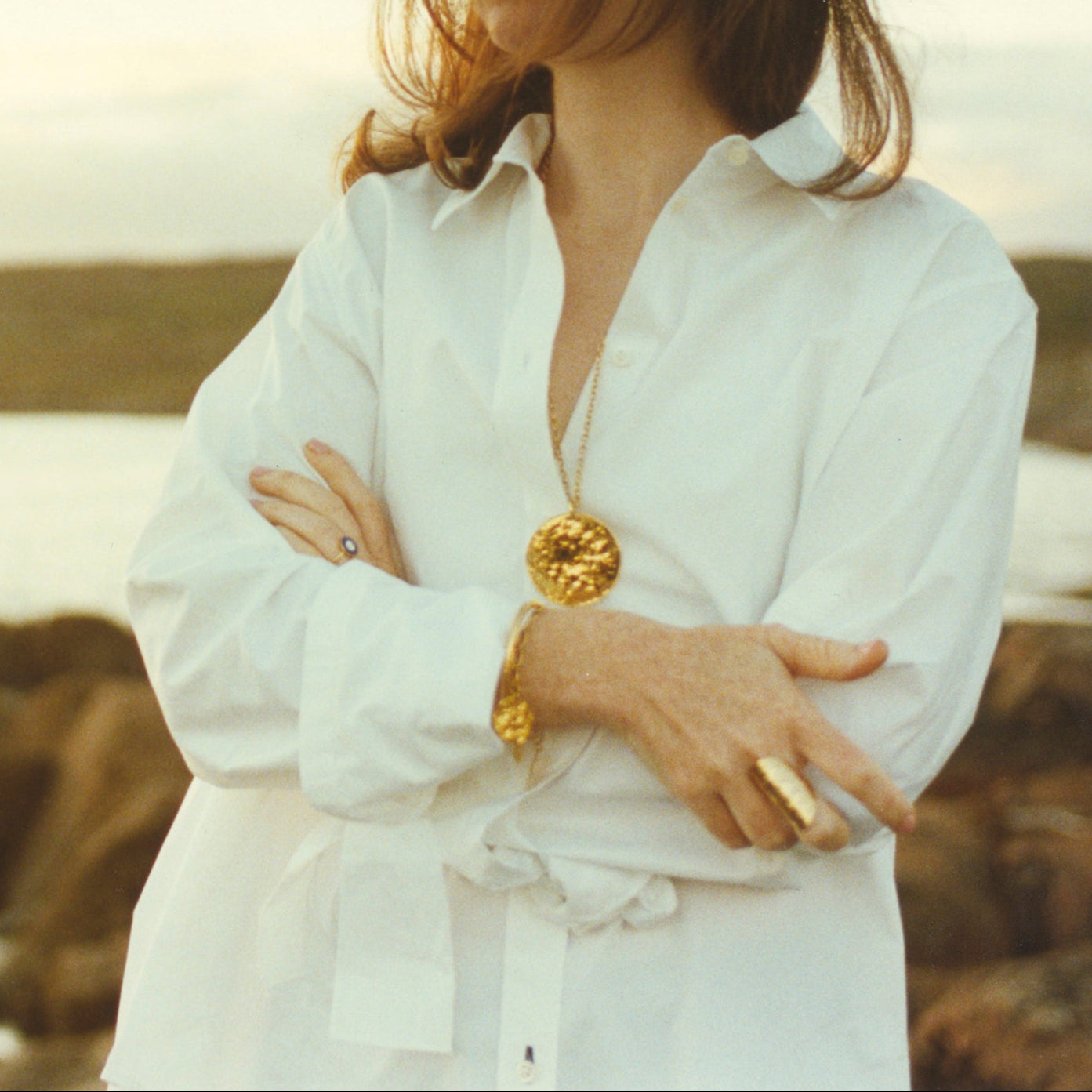Women with 18K yellow gold Grand Sun Shield Wrap Ring featuring a large 35mm hand-hammered gold sheet that wraps the finger by Isabella Roux