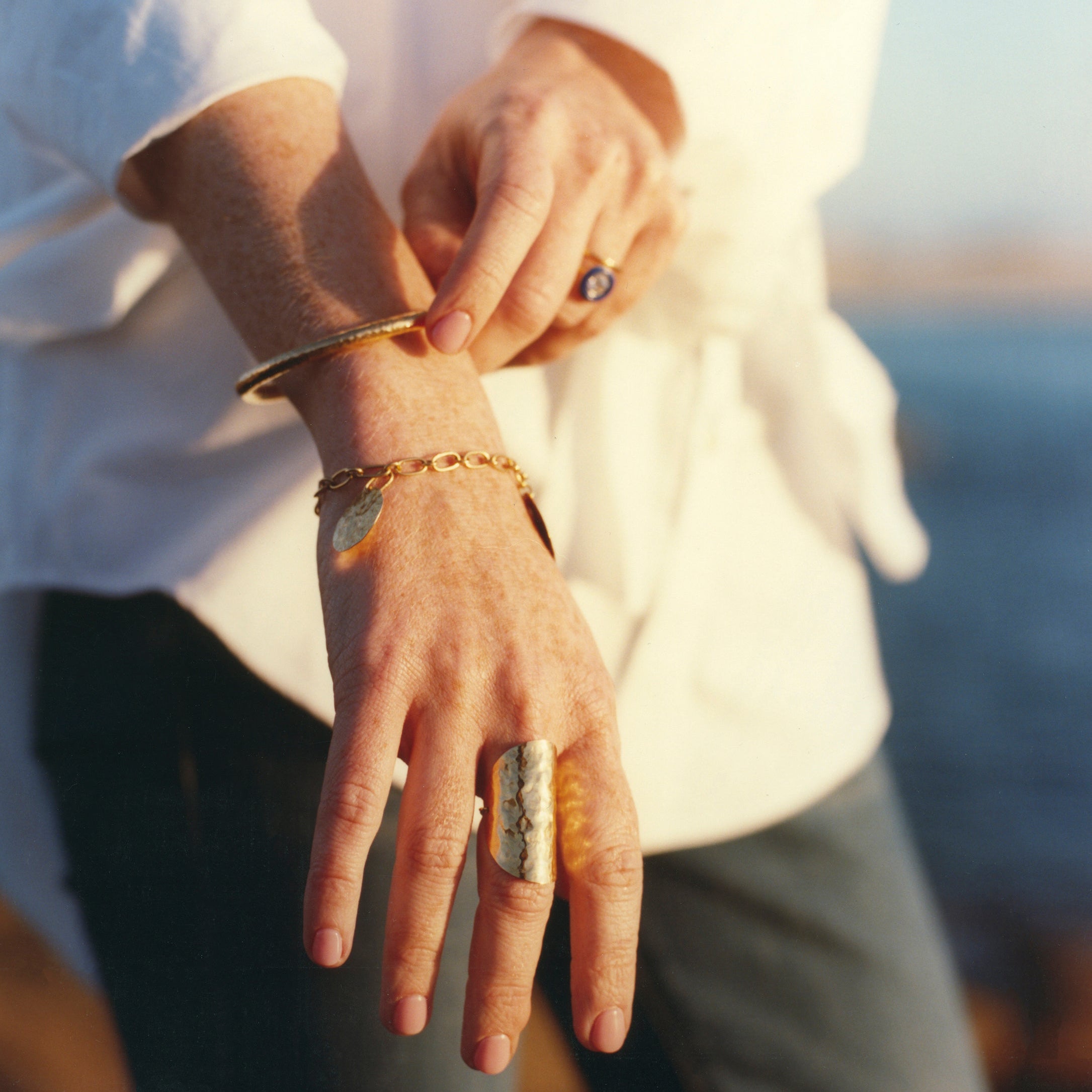 Women with 18K yellow gold Grand Sun Shield Wrap Ring featuring a large 35mm hand-hammered gold sheet that wraps the finger by Isabella Roux