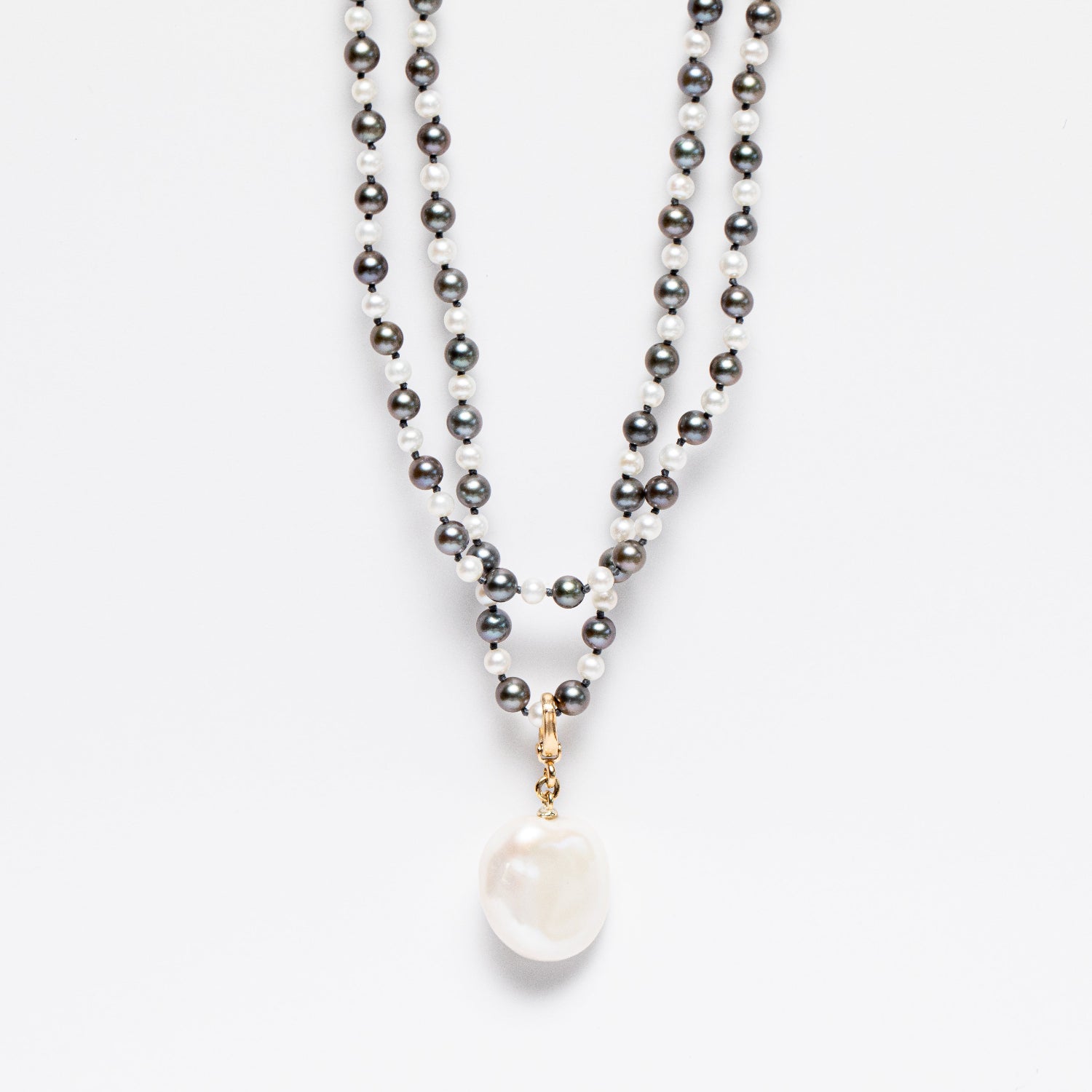 Handcrafted Pebble Grey & White Pearl Necklace featuring 4-5mm grey and white Akoya pearls knotted on silver grey thread with an 18K yellow gold clasp by Isabella Roux
