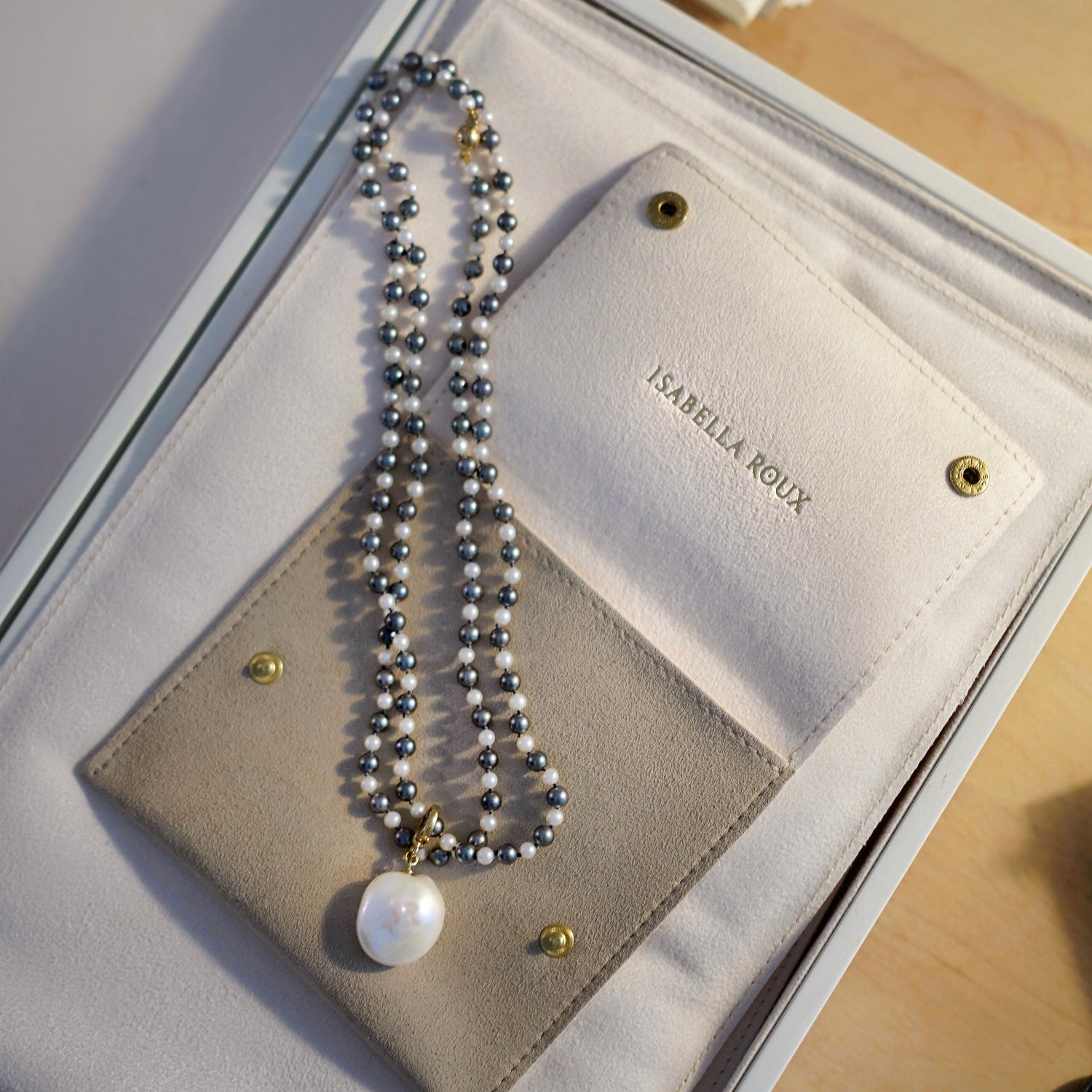 Handcrafted Pebble Grey & White Pearl Necklace featuring 4-5mm grey and white Akoya pearls knotted on silver grey thread with an 18K yellow gold clasp by Isabella Roux