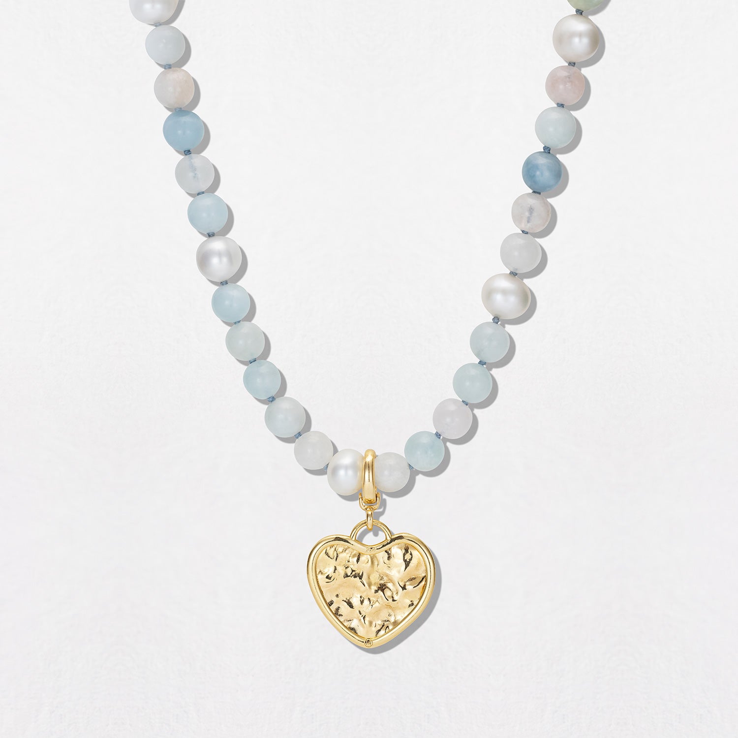 Hand-beaten 18K yellow gold Sun Disc Heart Charm Pendant featuring a 21mm heart-shaped textured gold disc with a smooth bezel and detachable clasp by Isabella Roux