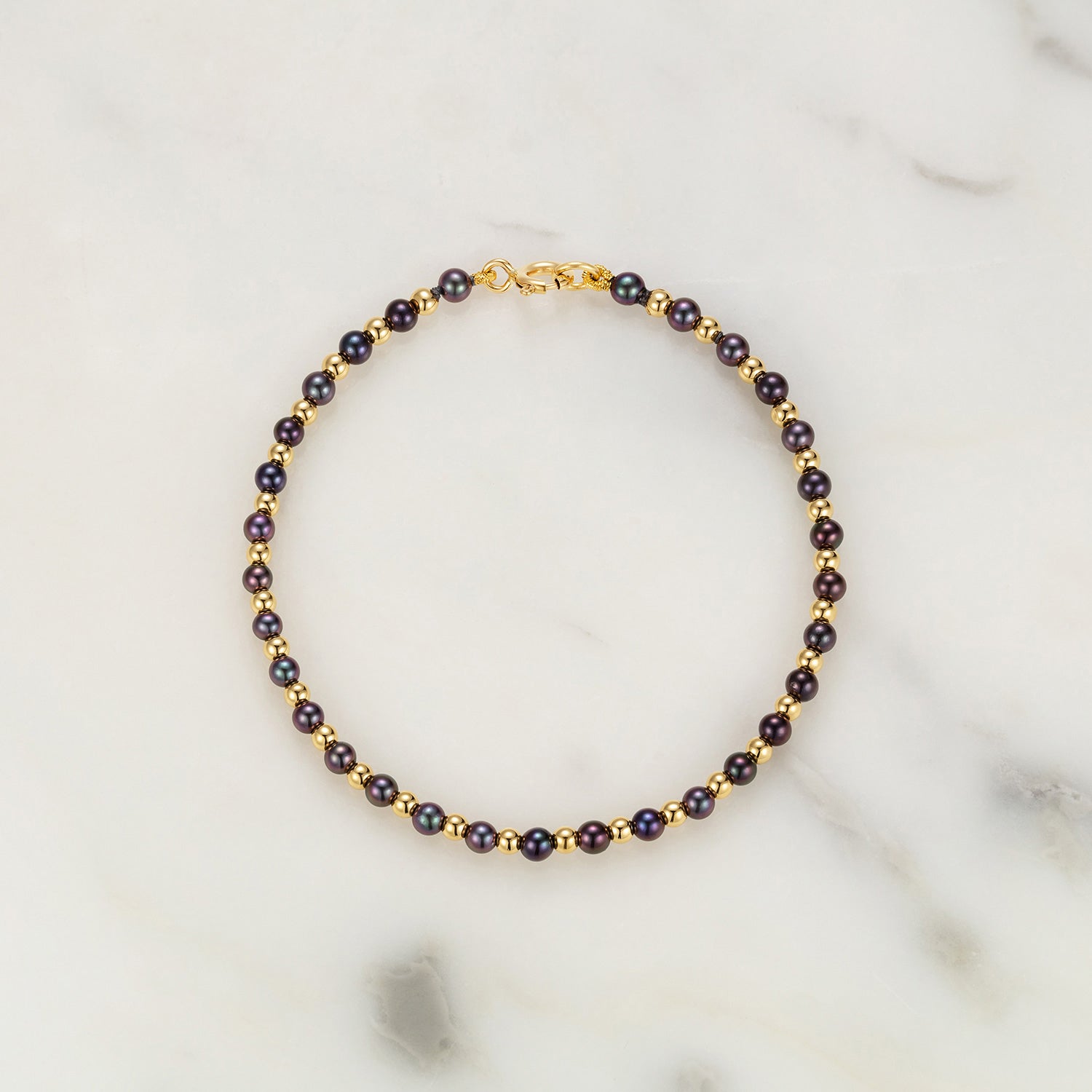 A Pearl & Gold Bead Bracelet with black Akoya pearls, 3mm in diameter, and 18K yellow gold beads and clasp. The length is 6.2".