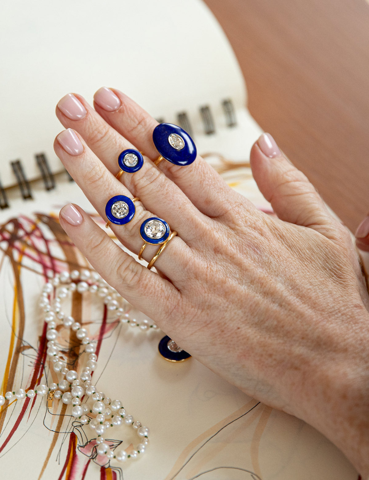 Bespoke 18K yellow & white gold Diamond & Lapis Rings featuring a 2.2ct round brilliant lab grown diamond and carved deep blue lapis lazuli in a halo around by Isabella Roux