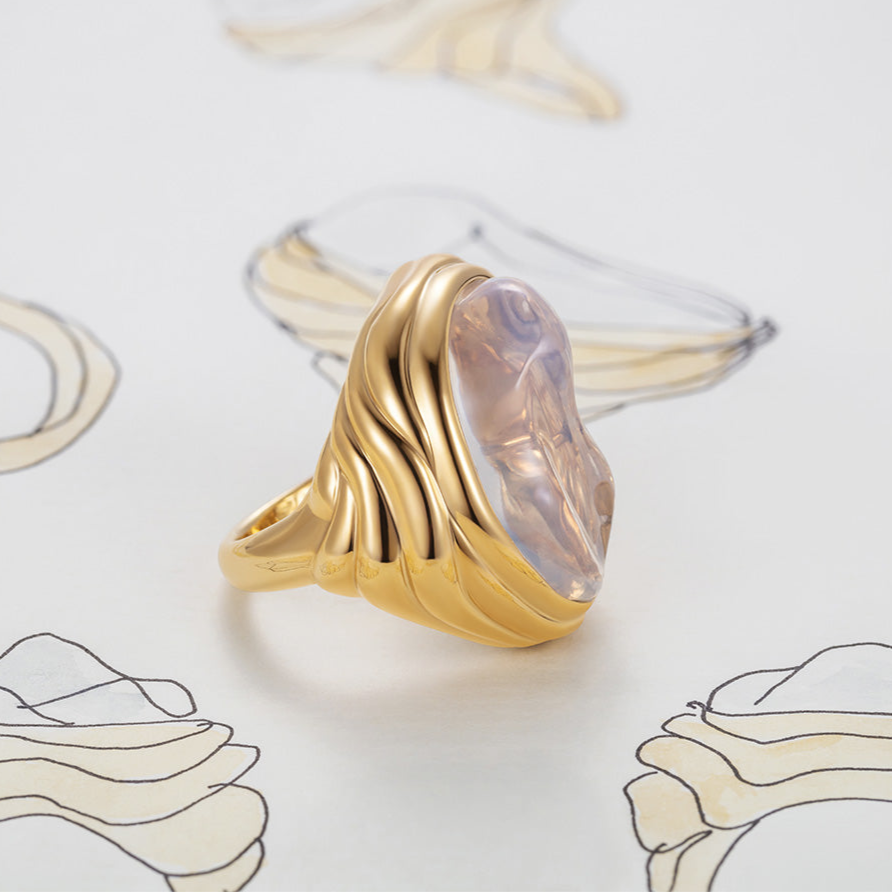 Bespoke carved gold ring with a pink stone on a light background by Isabella Roux