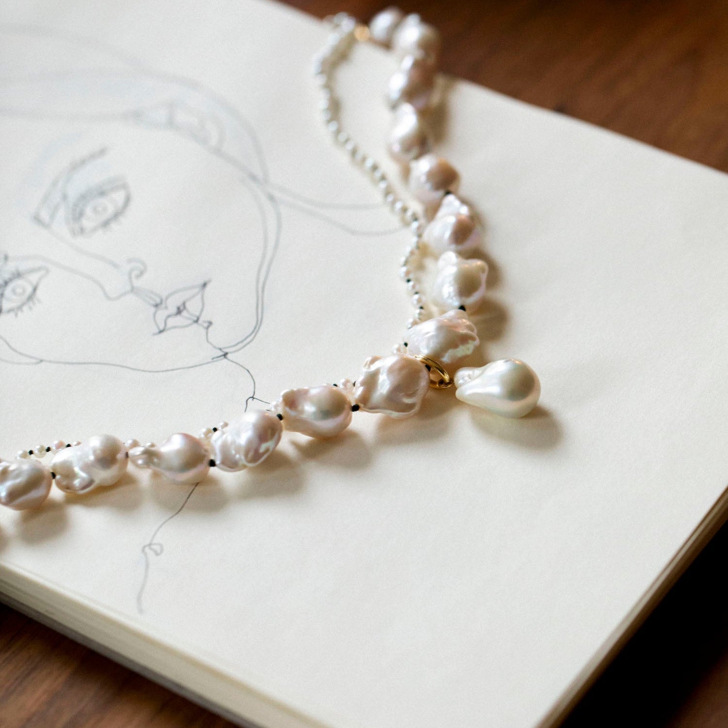 Handcrafted 18K yellow gold Baroque Pearl Necklace featuring unique white baroque freshwater pearls knotted on green thread by Isabella Roux
