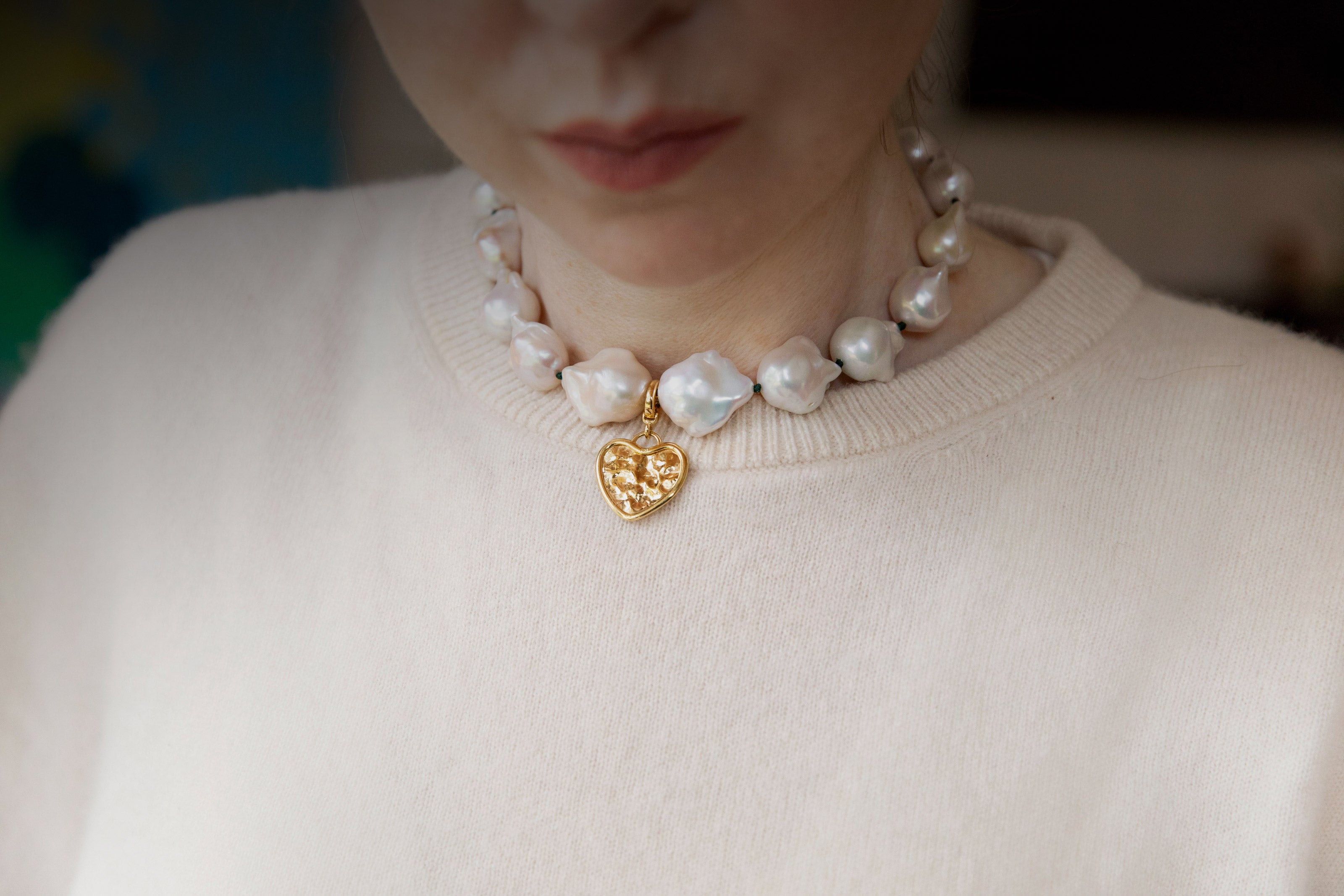 Handcrafted 18K yellow gold Baroque Pearl Necklace featuring unique white baroque freshwater pearls knotted on green thread with heart pendant by Isabella Roux