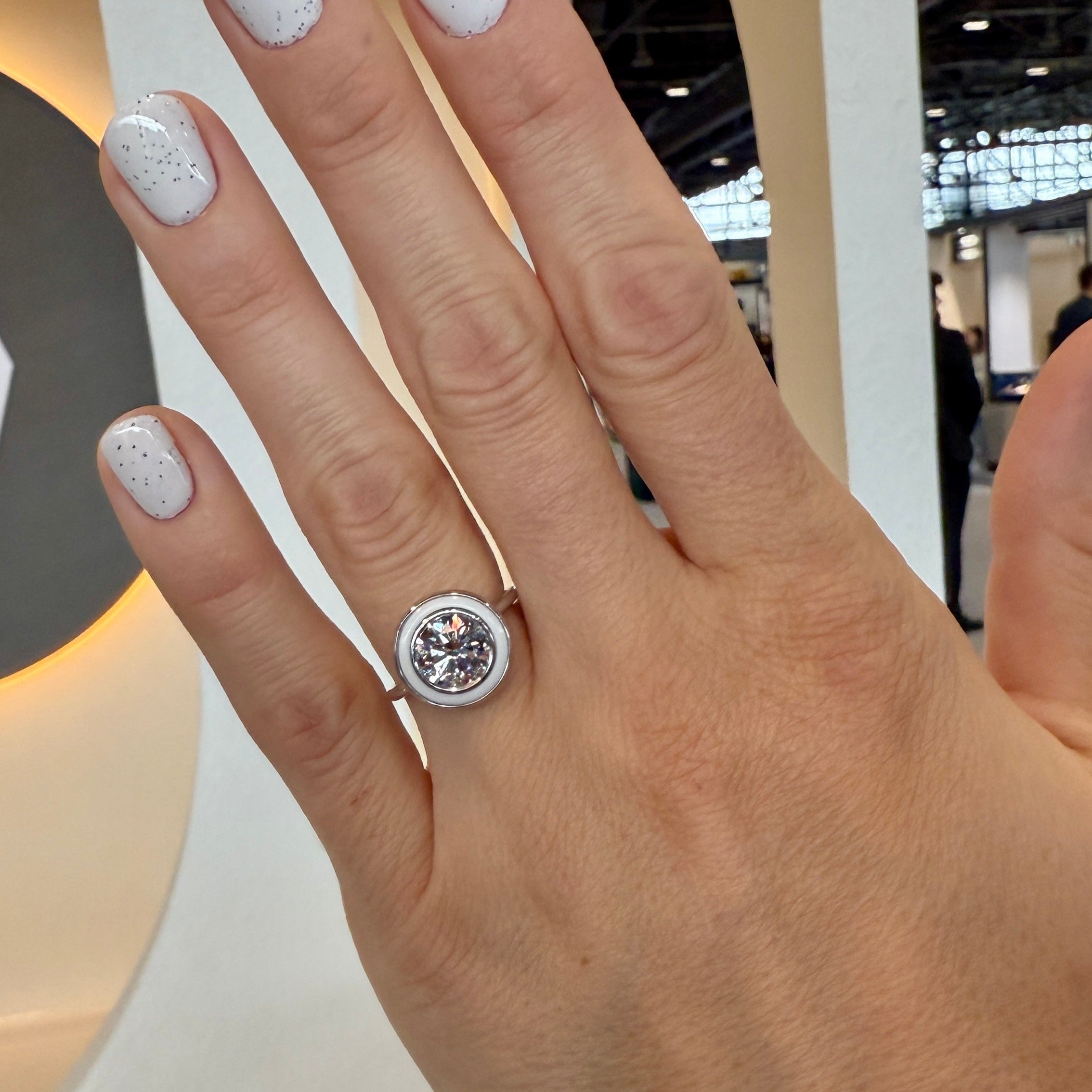 Hand wearing a bespoke 18K white gold Bespoke Classic Ring featuring a customisable 2ct round brilliant lab grown diamond and coloured hardstone of choice surround by Isabella Roux.