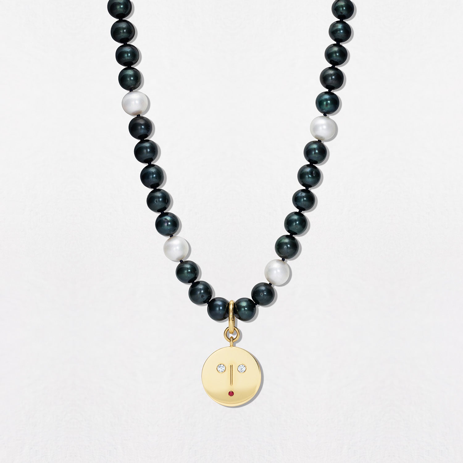 Pearl chain with 18K yellow gold Diamond & Ruby Face Charm Pendant featuring a stylized face set with sparkling diamond eyes and ruby mouth by Isabella Roux.