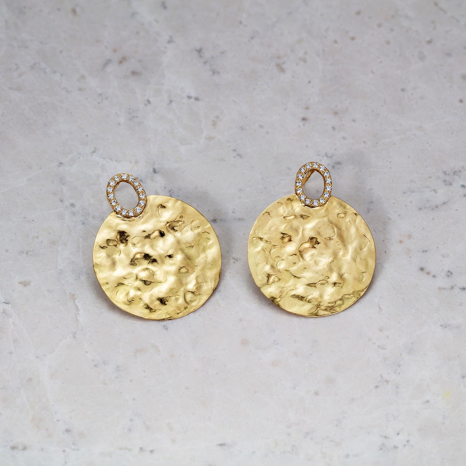 Hand-beaten 18K yellow gold Diamond Sun Disc Earrings featuring 25mm discs set with 0.30cts of sparkling round pavé diamonds by Isabella Roux on stone surface