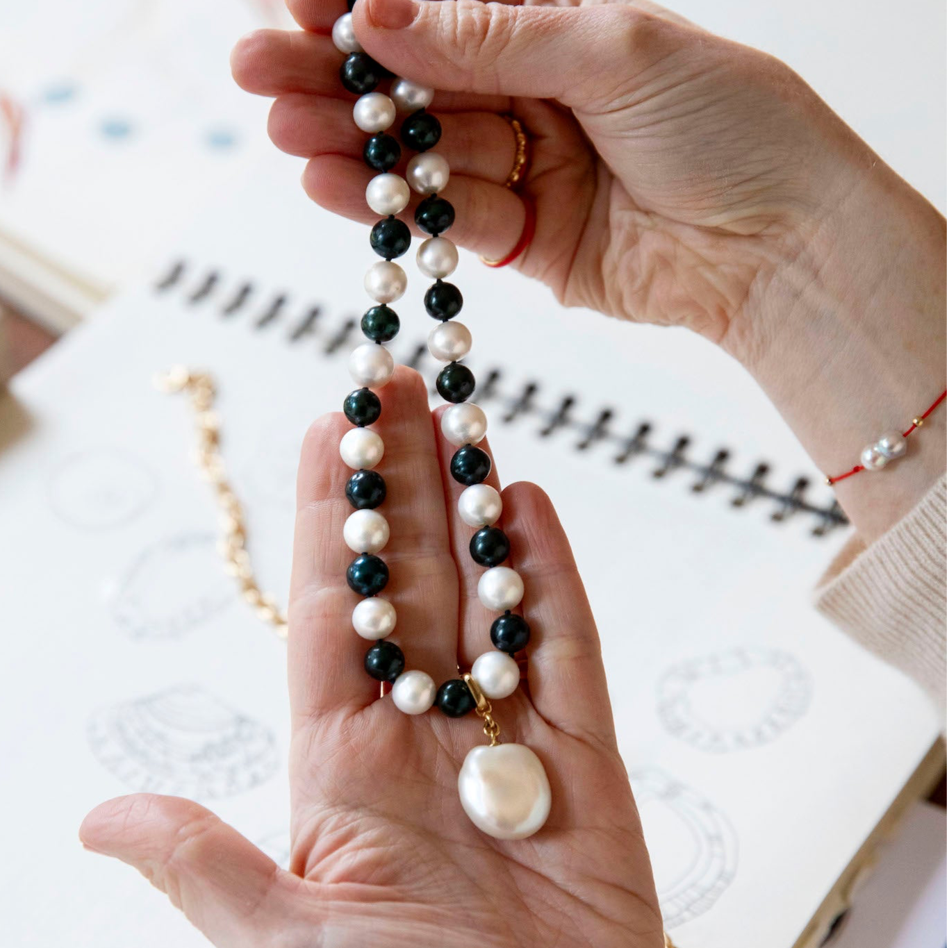 Handcrafted Pebble Monochrome Necklace featuring a set of black and white freshwater pearls knotted on navy thread with 18K yellow gold fittings by Isabella Roux
