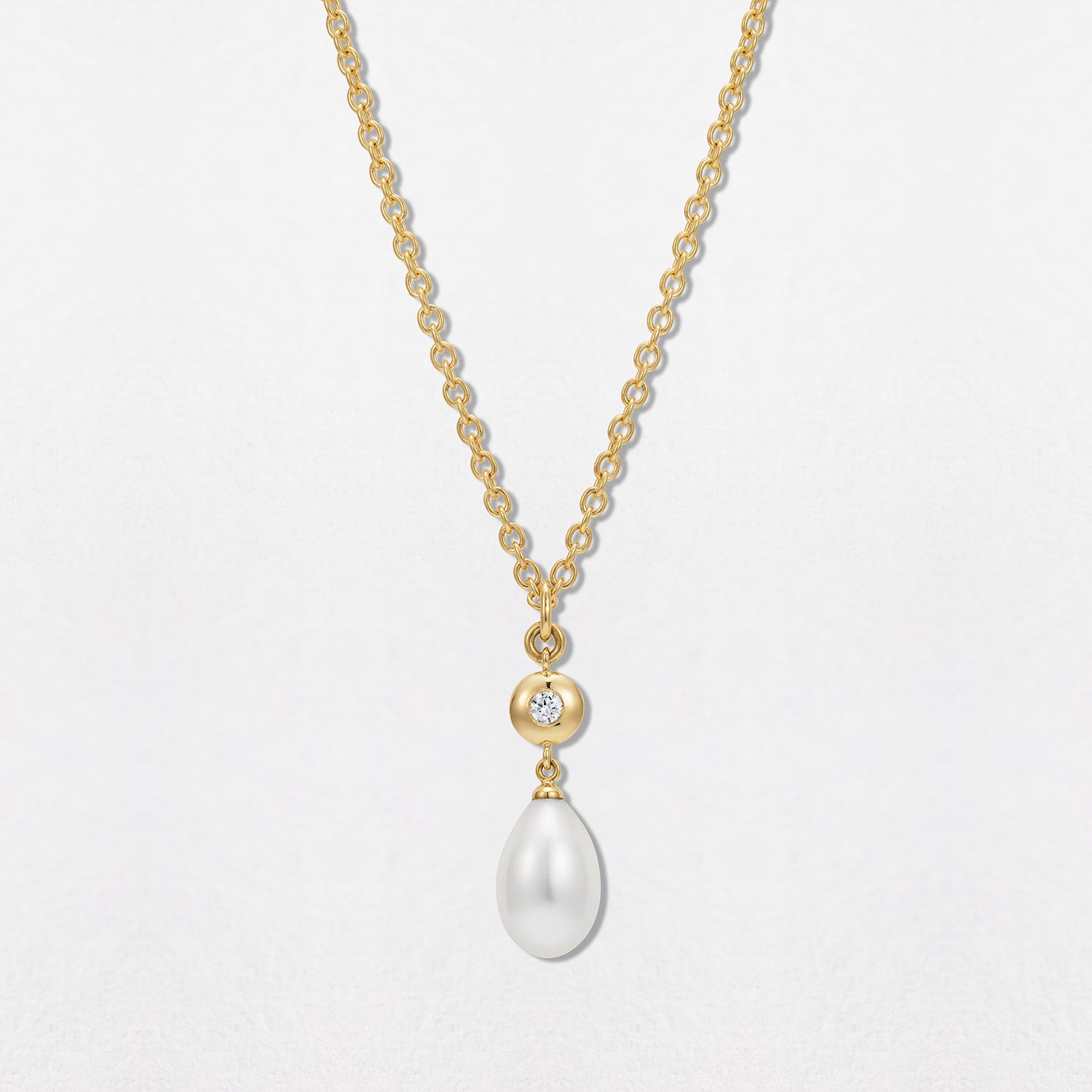 Handcrafted 18K yellow gold Pebble Pearl & Diamond Pendant featuring a 0.10ct round brilliant-cut lab diamond bezel-set in a signature gold pebble shape with a white Akoya pearl drop on a 22" chain by Isabella Roux.