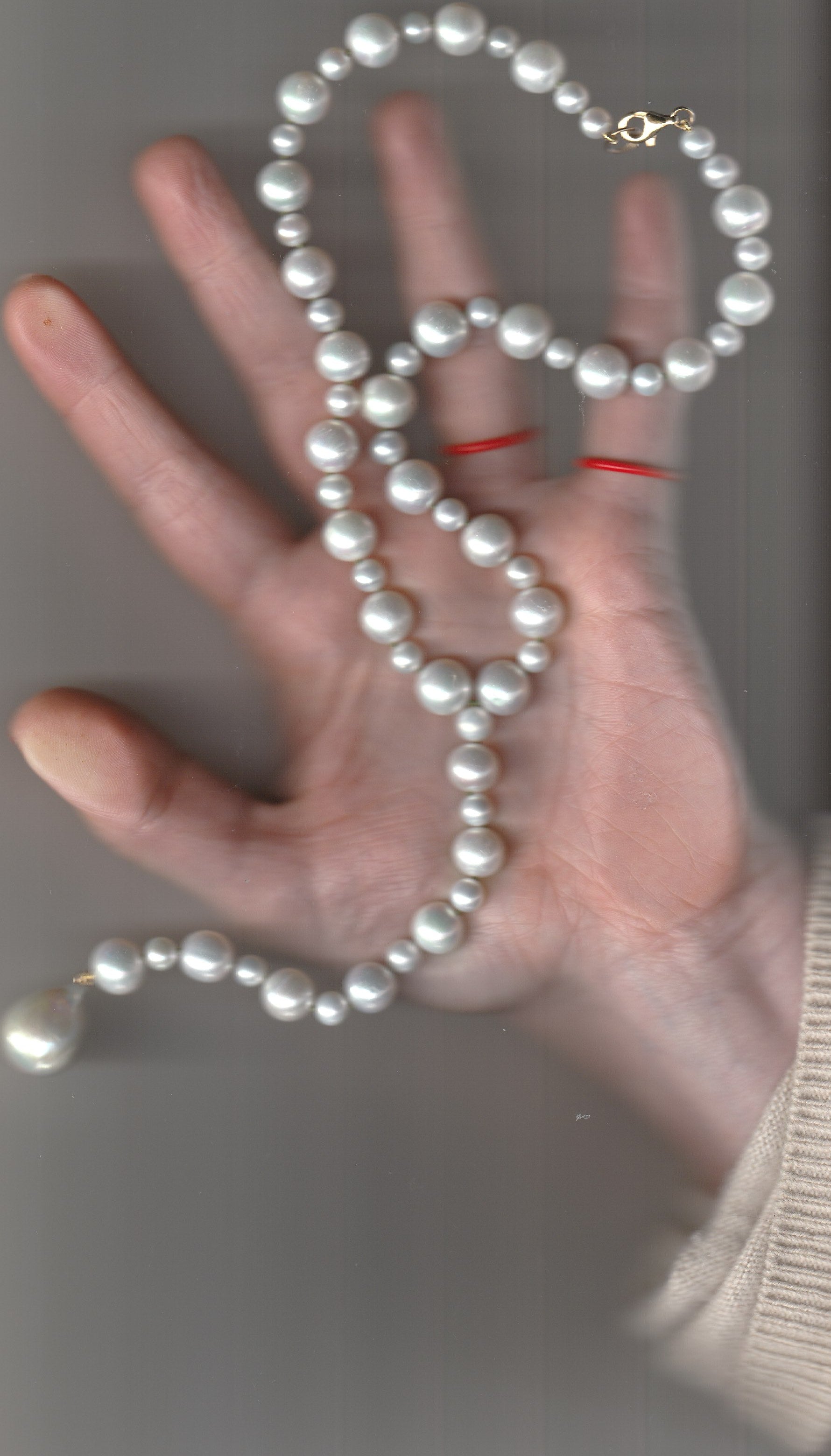 Handcrafted Pebble Pearl Drop Necklace featuring a main pearl and graduating pebble pearls, with 18K yellow gold clasp on green thread, by Isabella Roux