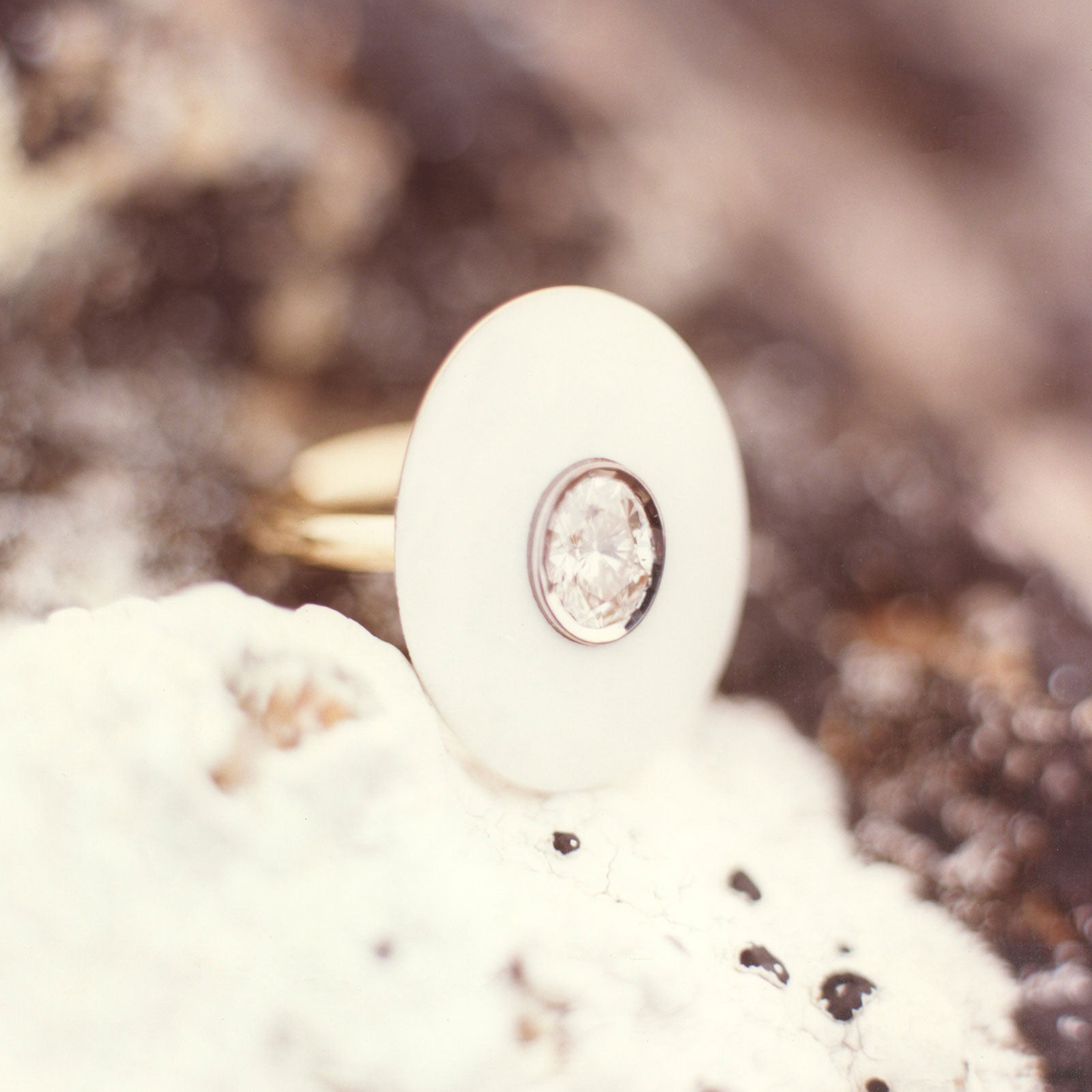 Close-up of a 18k gold bespoke gemstone and diamond ring on a blurred background by Isabella Roux