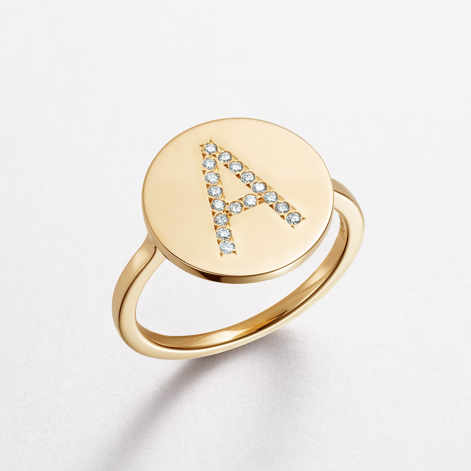 Bespoke 18K yellow gold Signature Alphabet Ring featuring custom lettering with white diamond accents by Isabella Roux.