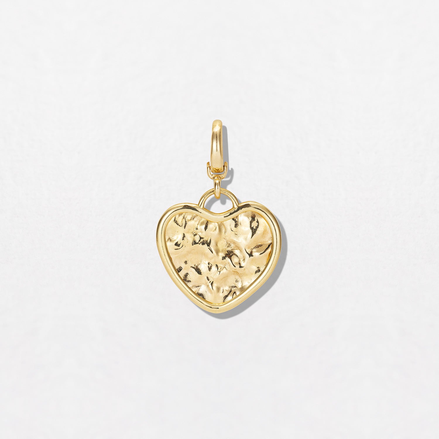 Hand-beaten 18K yellow gold Sun Disc Heart Charm Pendant featuring a 21mm heart-shaped textured gold disc with a smooth bezel and detachable clasp by Isabella Roux