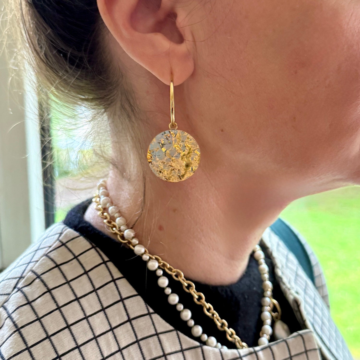 Woman wearing handcrafted 18K yellow gold Sun Disc Large Hoop Earrings featuring 25mm hoops with detachable 25mm hand-beaten gold discs by Isabella Roux.